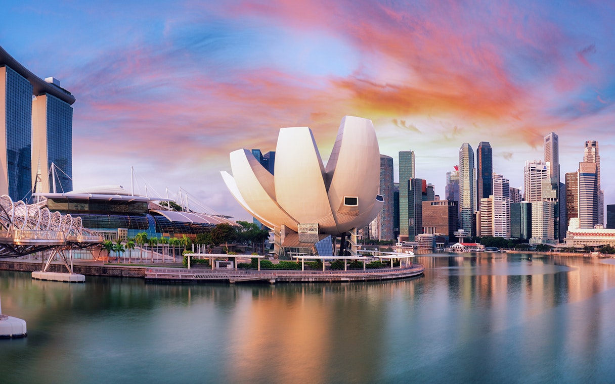 ArtScience Museum in Singapore with city skyline at sunset.