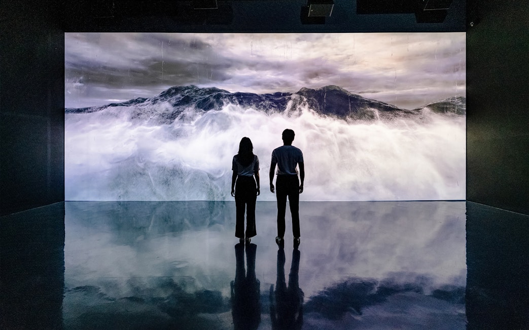 Visitors viewing ocean waves at Arte Museum Dubai's virtual experience.