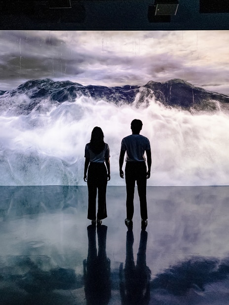 Visitors viewing ocean waves at Arte Museum Dubai's virtual experience.