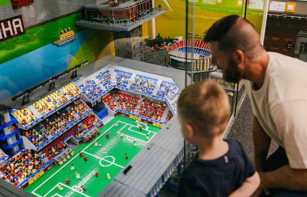 Father and son viewing a Lego soccer stadium at the Museum of Bricks.