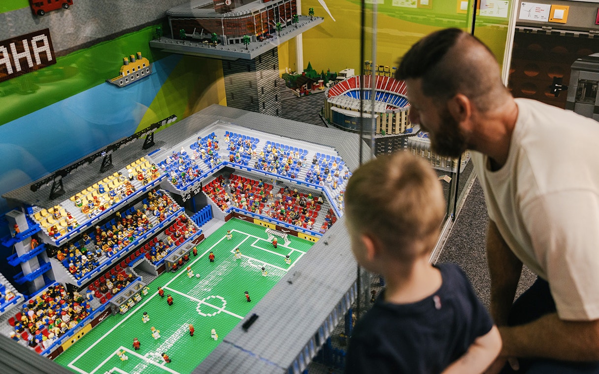 Father and son viewing a Lego soccer stadium at the Museum of Bricks.