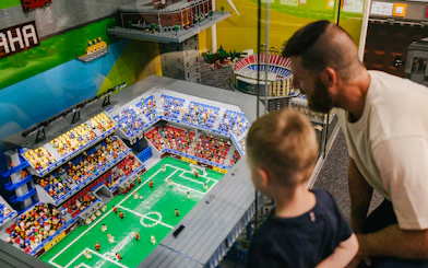 Father and son viewing a Lego soccer stadium at the Museum of Bricks.
