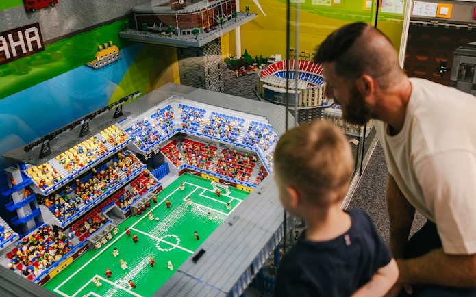 Father and son viewing a Lego soccer stadium at the Museum of Bricks.