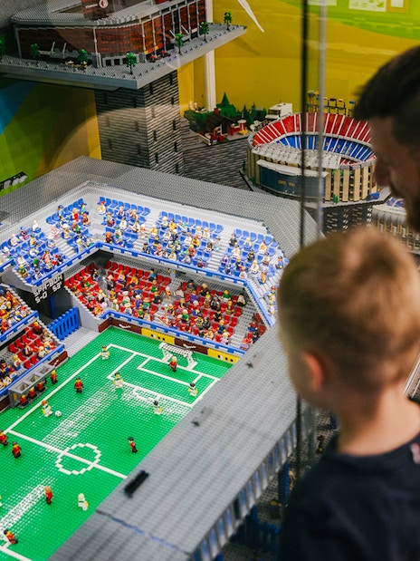 Father and son viewing a Lego soccer stadium at the Museum of Bricks.