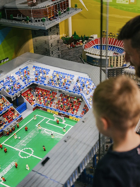 Father and son viewing a Lego soccer stadium at the Museum of Bricks.