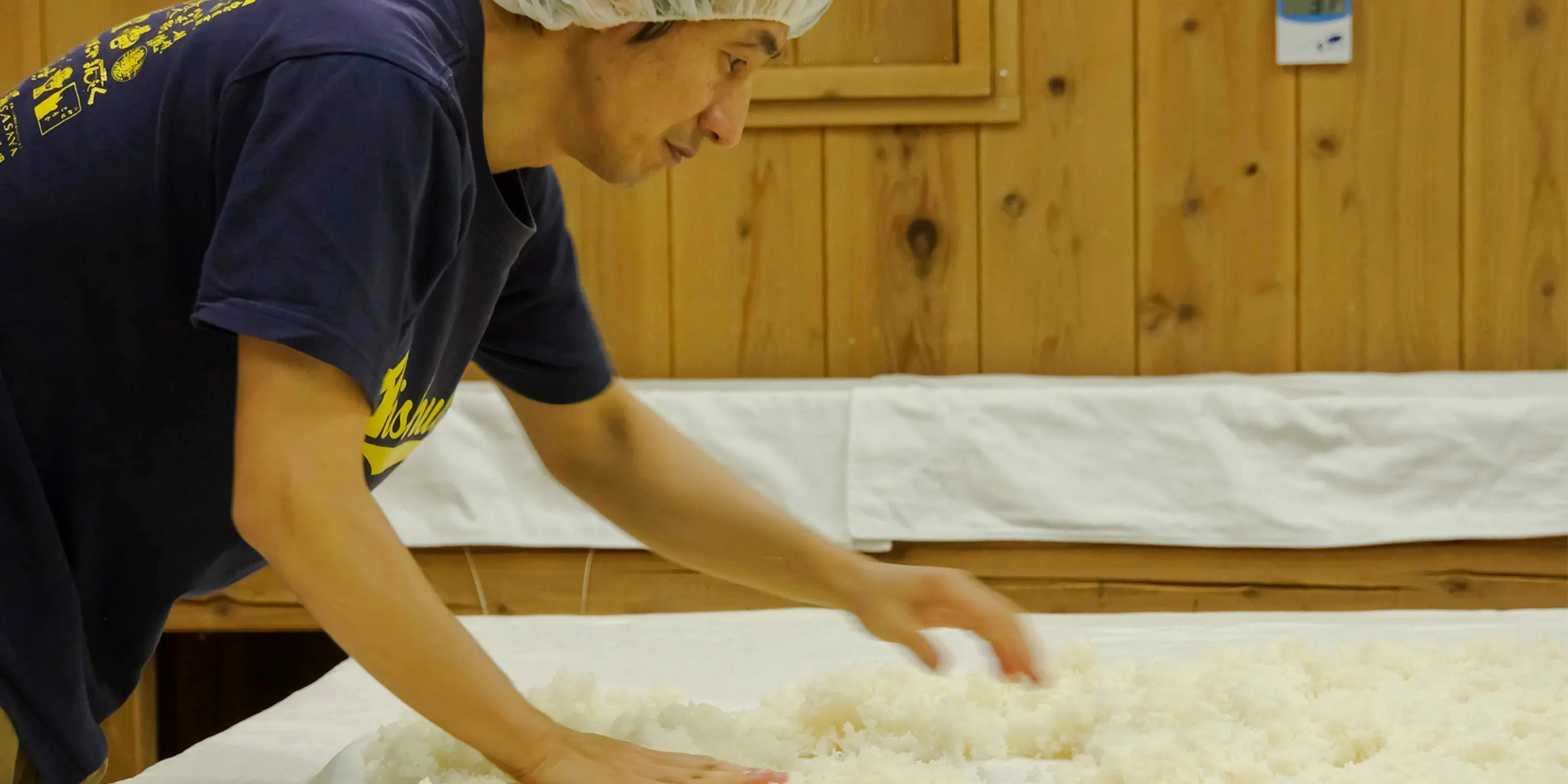 Man preparing rice for fermentation at Kitajima Sake Brewery, Shiga.