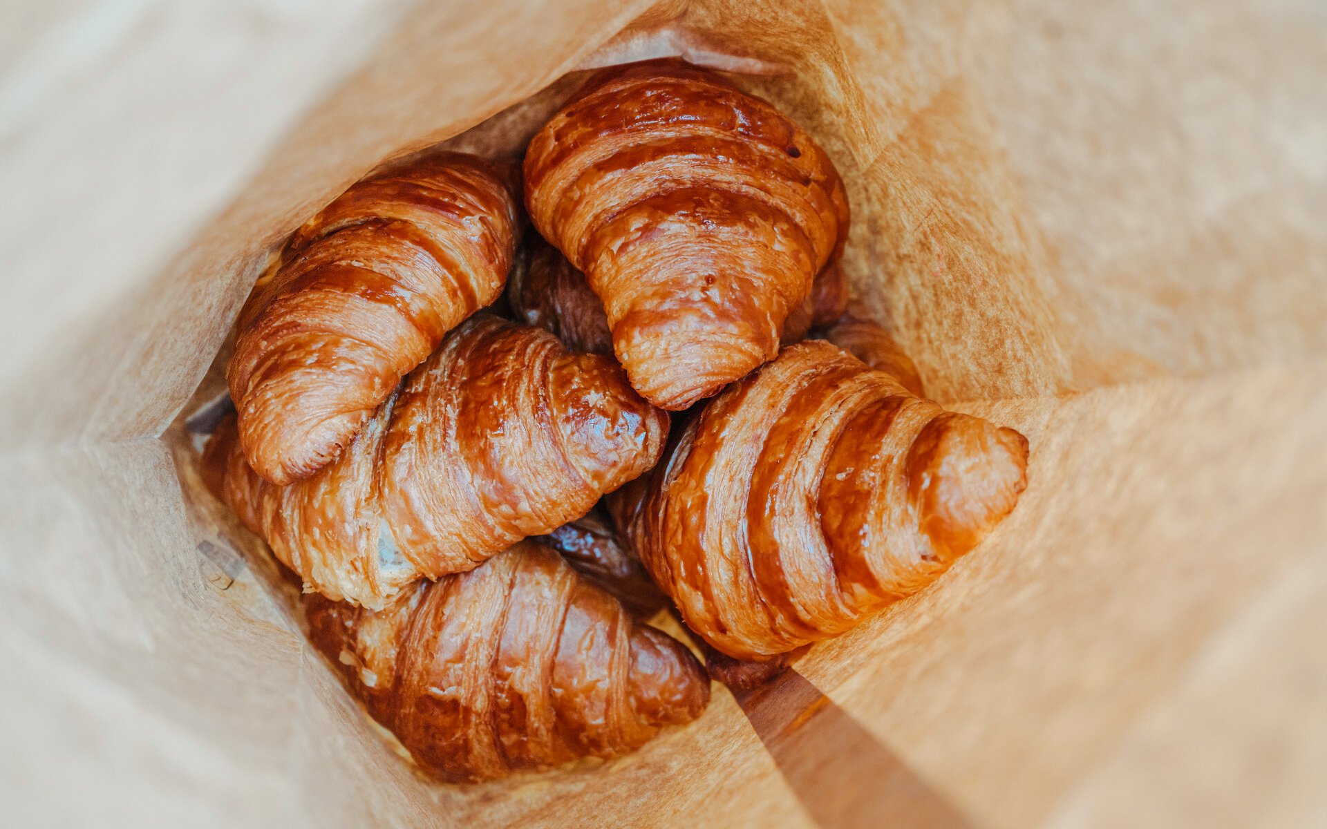 Croissants in a paper bag, part of the Ultimate Paris Food Tour.