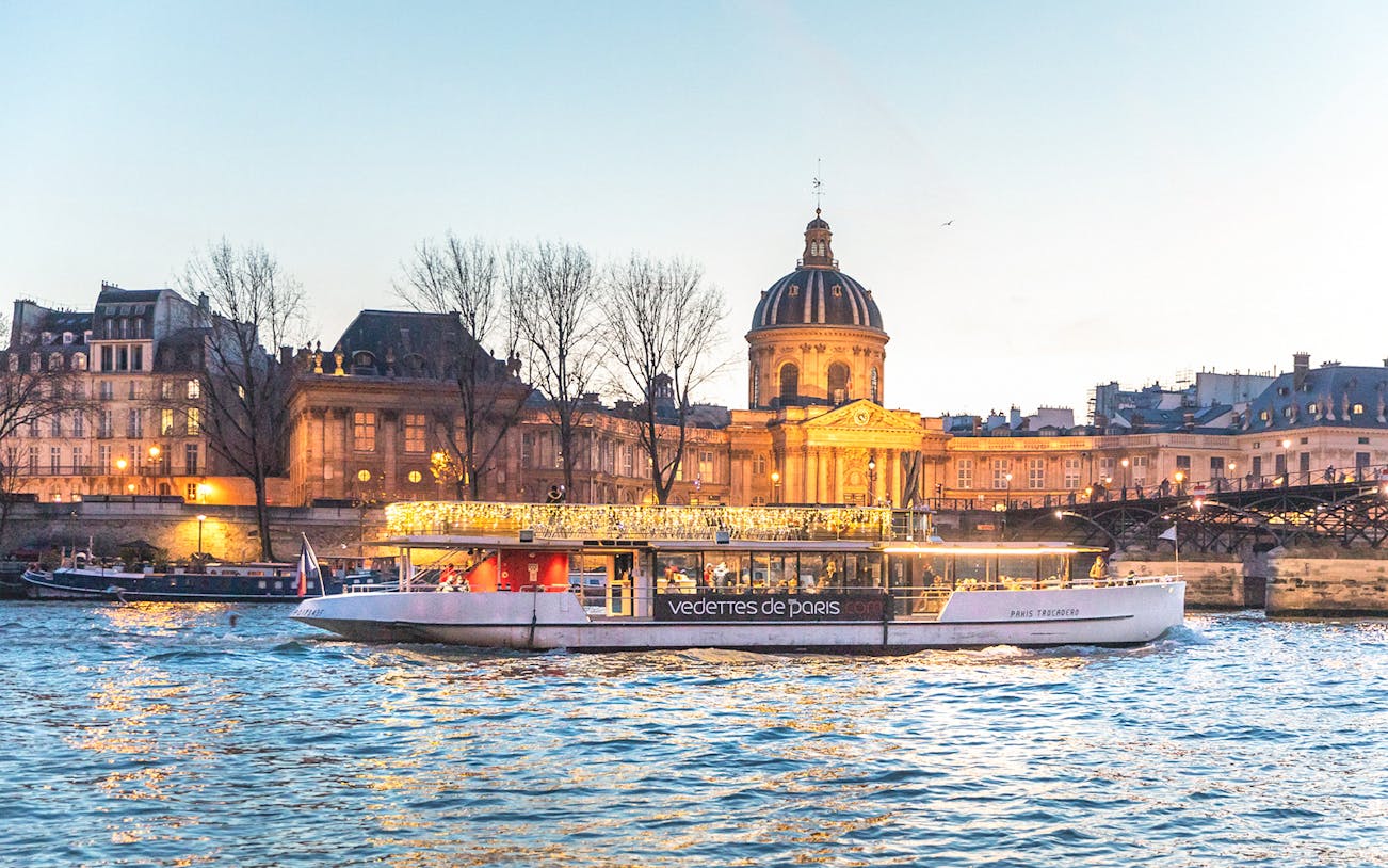 Evening cruise on the Seine River with Institut de France in the background, Paris.