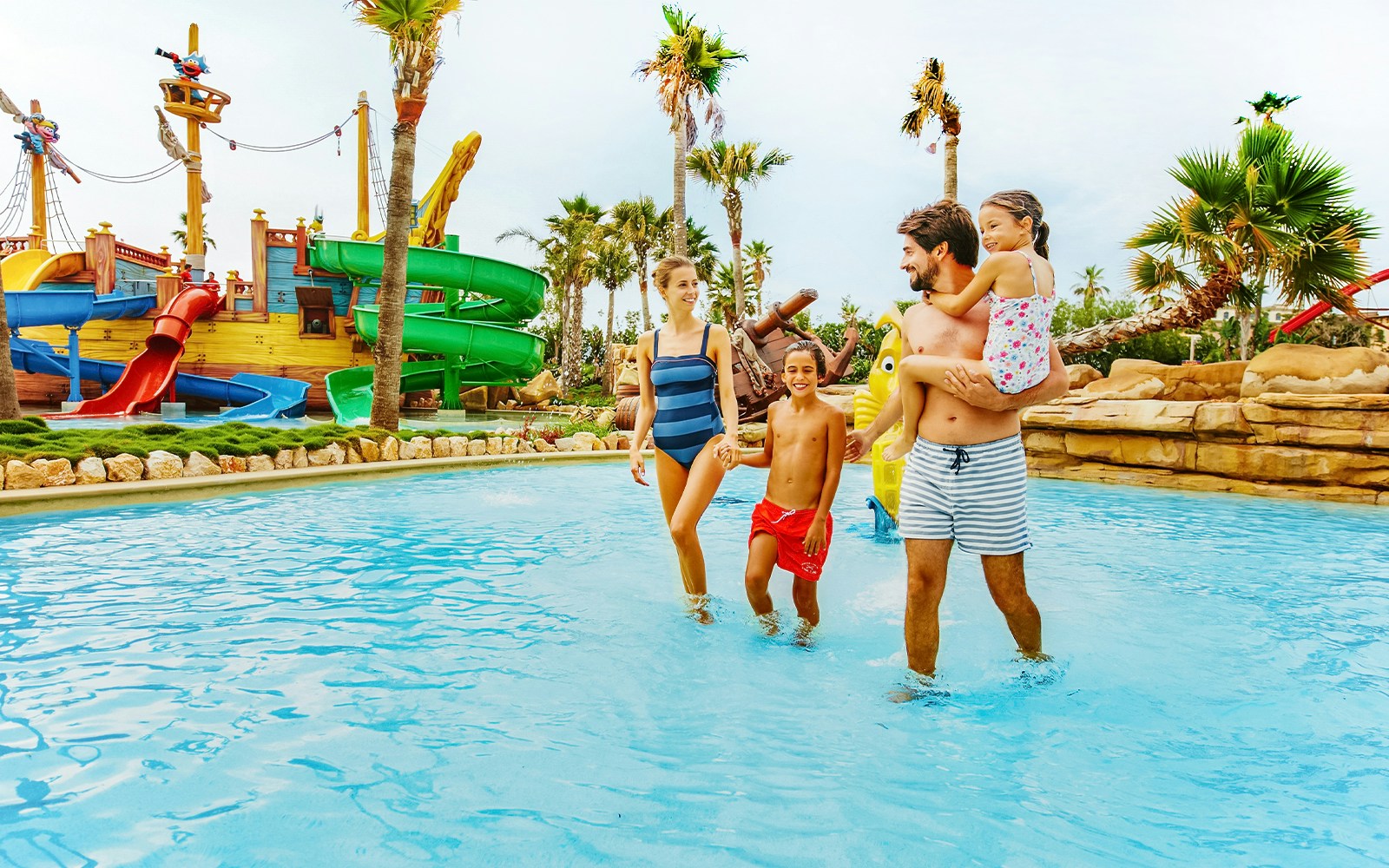happy family consiting of different aged members in a pool slide at costa cabine port aventura
