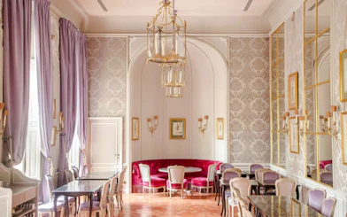 Elegant dining room at Caumont Centre d’Art with ornate chandeliers and plush seating.