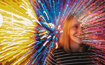 Person experiencing colorful light effects at Infinity Corridor, Camera Obscura & World of Illusions, Edinburgh.