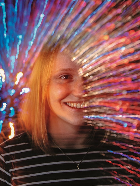 Person experiencing colorful light effects at Infinity Corridor, Camera Obscura & World of Illusions, Edinburgh.