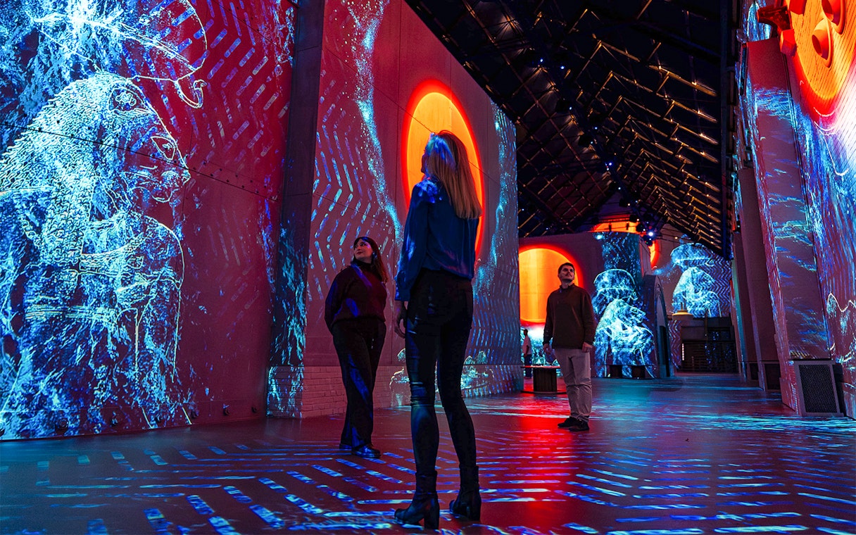 Visitors exploring digital art projections at Fabrique des Lumières: The Kingdom of the Pharaohs exhibition.