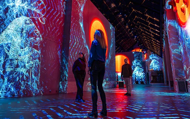 Visitors exploring digital art projections at Fabrique des Lumières: The Kingdom of the Pharaohs exhibition.