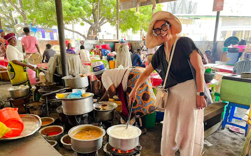 Cooking demonstration at a local market in Dar es Salaam during a Zanzibar day trip.