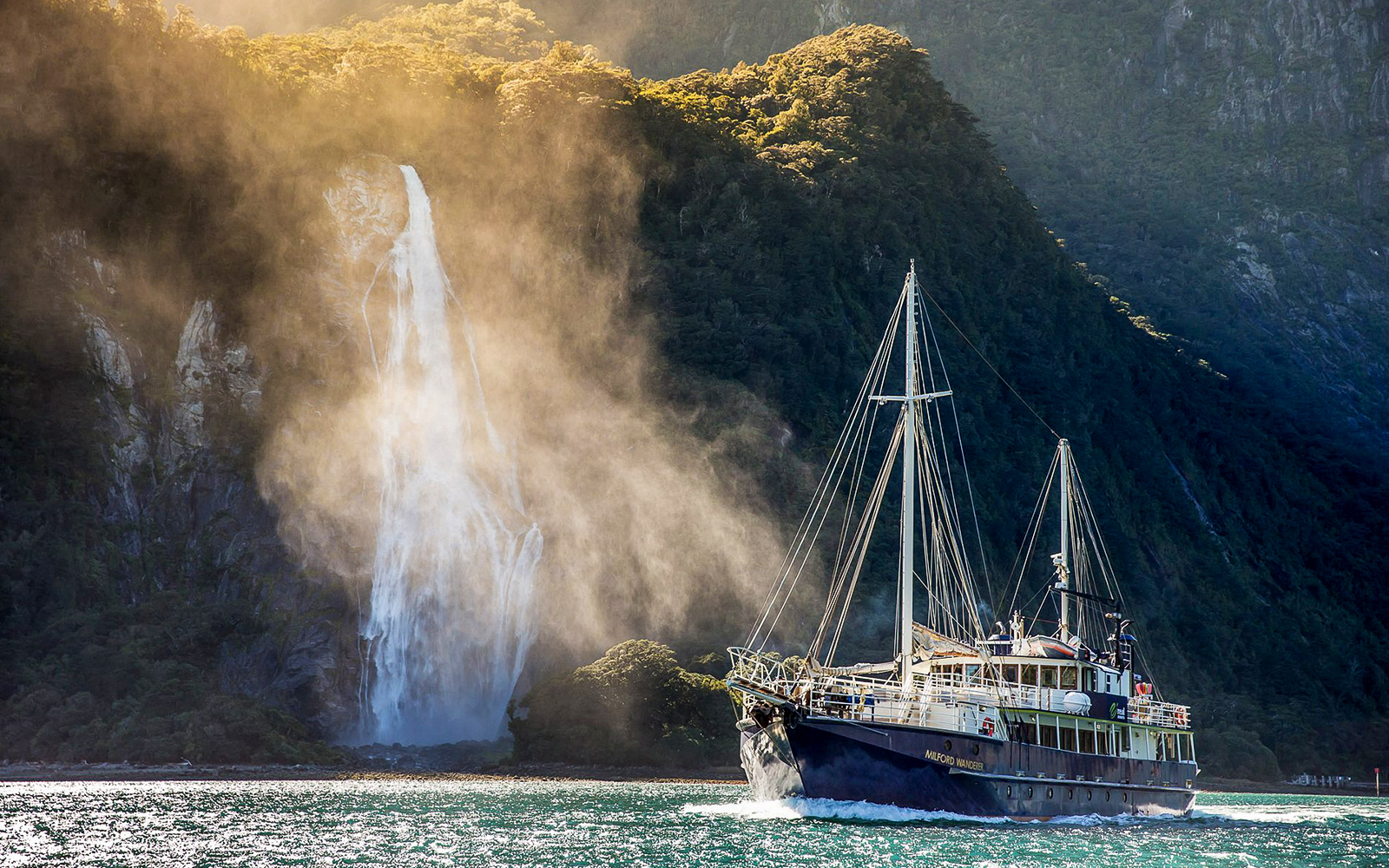 Cruise ship near waterfall in Doubtful Sound, New Zealand.