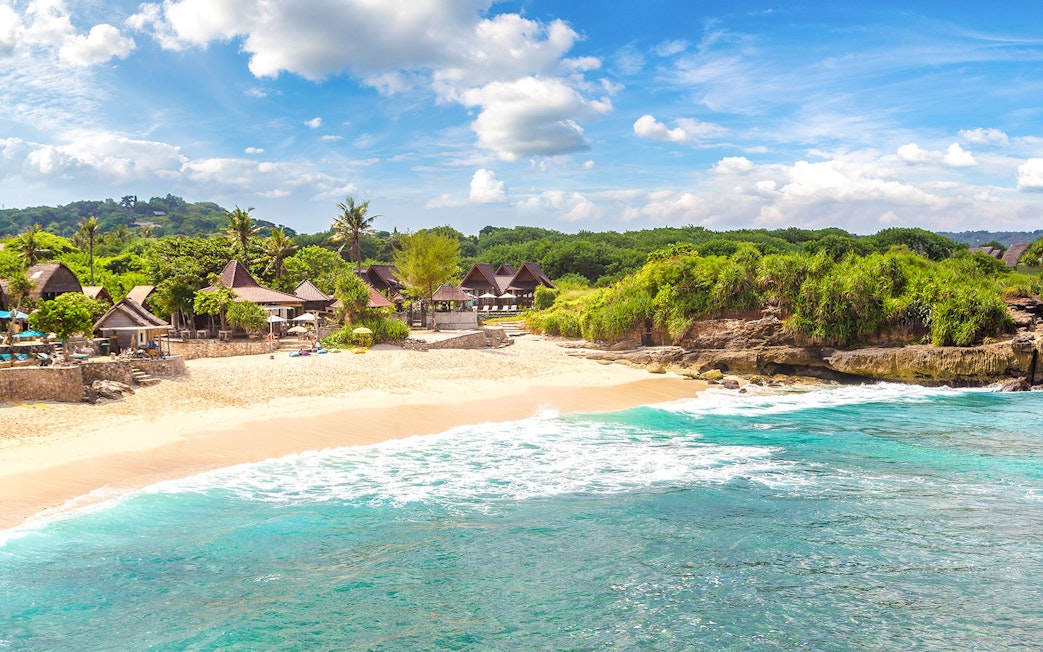 Nusa Lembongan Dream beach with turquoise water and traditional huts along the shore.