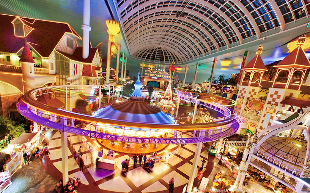 Indoor amusement park ride at Lotte World, Seoul, featuring colorful lights and a domed ceiling.