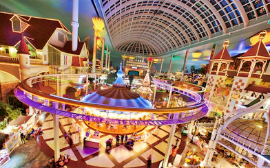 Indoor amusement park ride at Lotte World, Seoul, featuring colorful lights and a domed ceiling.