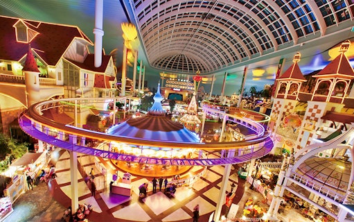 Indoor amusement park ride at Lotte World, Seoul, featuring colorful lights and a domed ceiling.