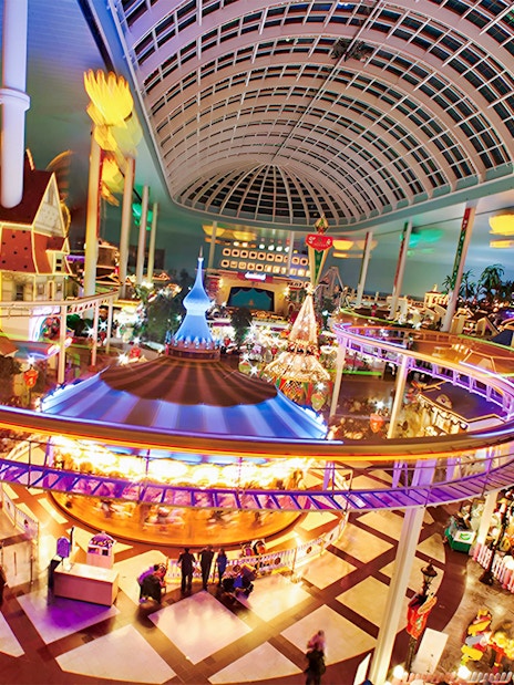 Indoor amusement park ride at Lotte World, Seoul, featuring colorful lights and a domed ceiling.