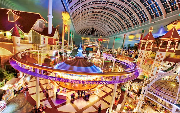 Indoor amusement park ride at Lotte World, Seoul, featuring colorful lights and a domed ceiling.