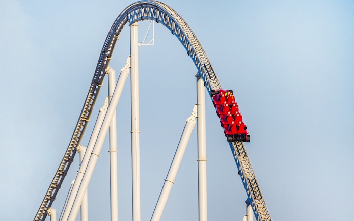 Roller coaster at Ferrari World Abu Dhabi with red cars on a steep track.