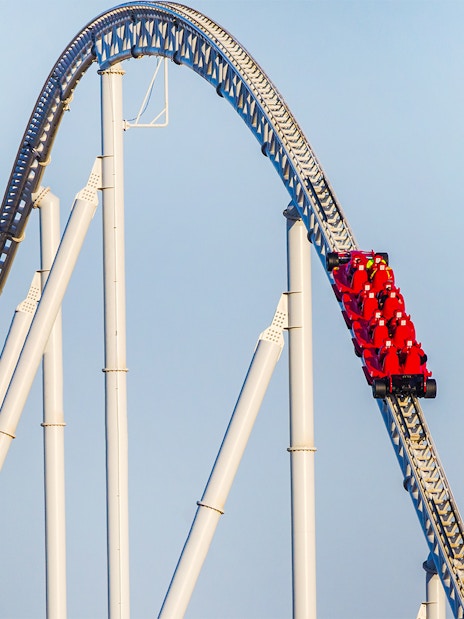 Roller coaster at Ferrari World Abu Dhabi with red cars on a steep track.