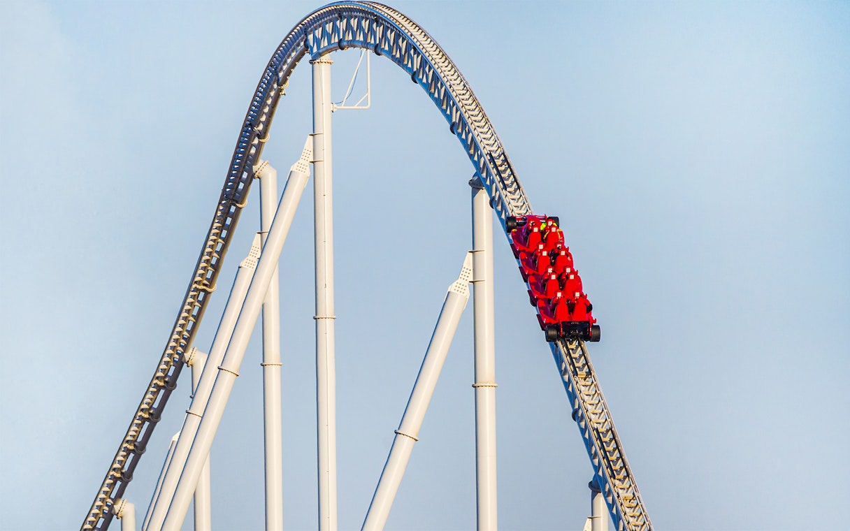 Roller coaster at Ferrari World Abu Dhabi with red cars on a steep track.