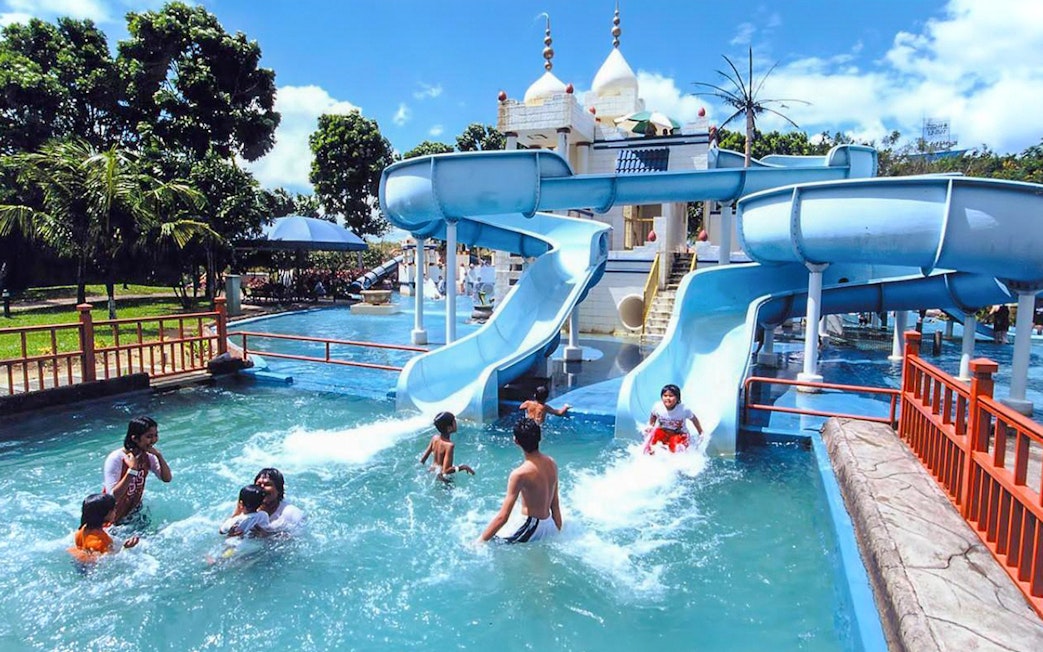 Family enjoying water slides at A'Famosa Melaka Waterpark, Malaysia.