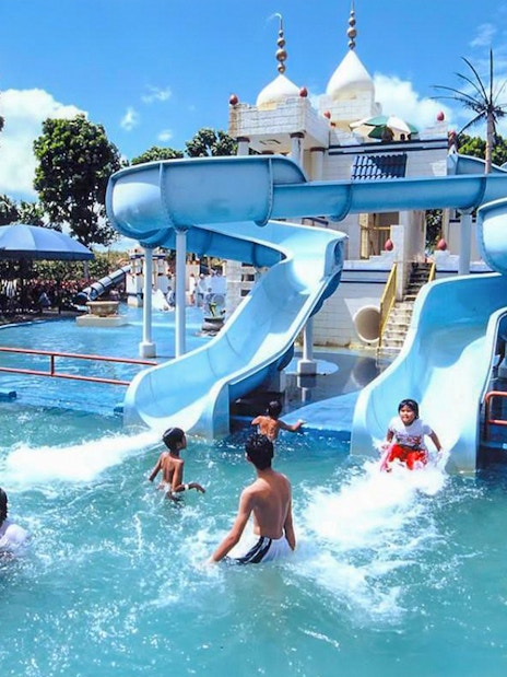 Family enjoying water slides at A'Famosa Melaka Waterpark, Malaysia.
