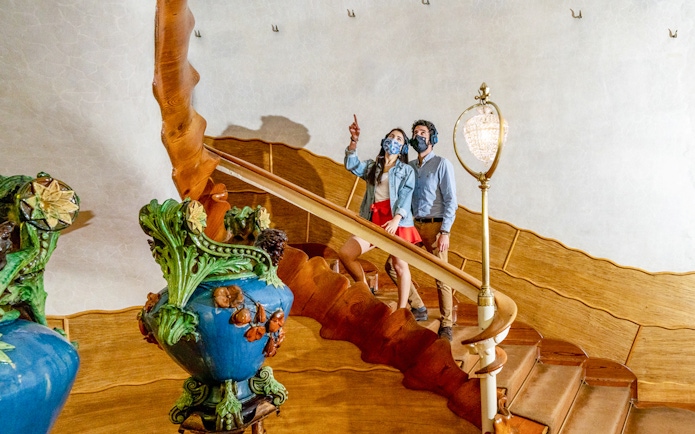 Visitors exploring the ornate staircase of Casa Batlló in Barcelona.