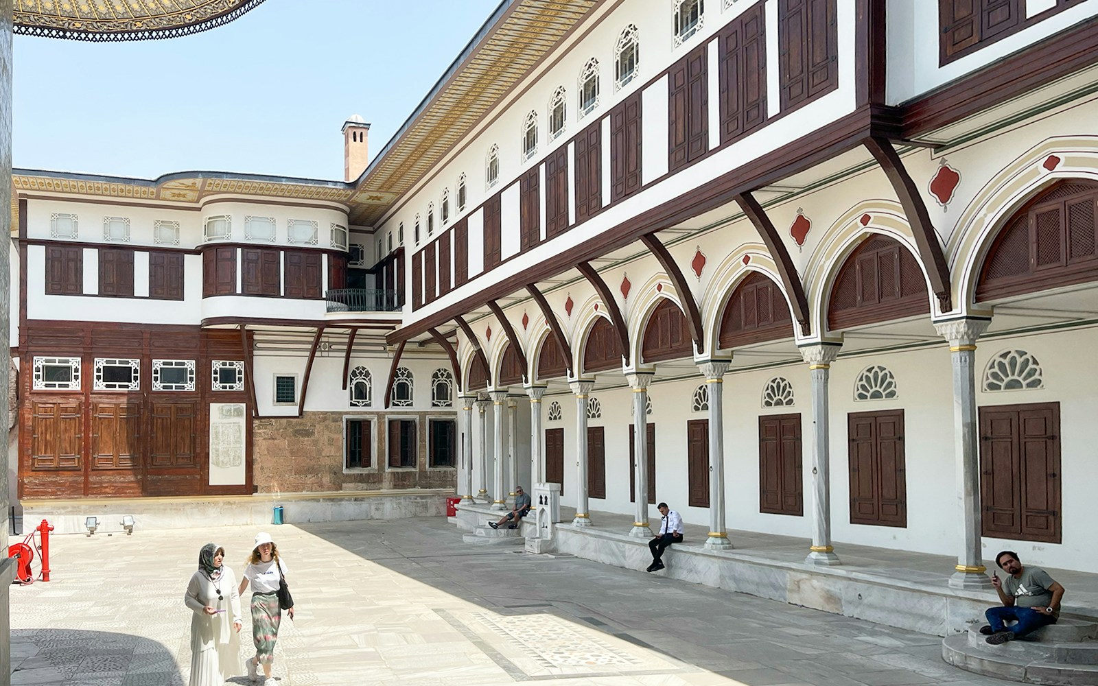 Topkapi Palace Museum courtyard with tourists exploring historic architecture in Istanbul.