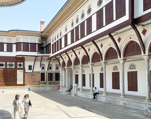 Topkapi Palace Museum courtyard with tourists exploring historic architecture in Istanbul.
