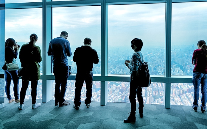 Visitors enjoying the view from Taipei 101 Observatory, overlooking Taipei city.