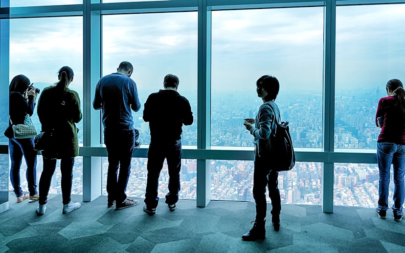Visitors enjoying the view from Taipei 101 Observatory, overlooking Taipei city.