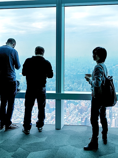Visitors enjoying the view from Taipei 101 Observatory, overlooking Taipei city.