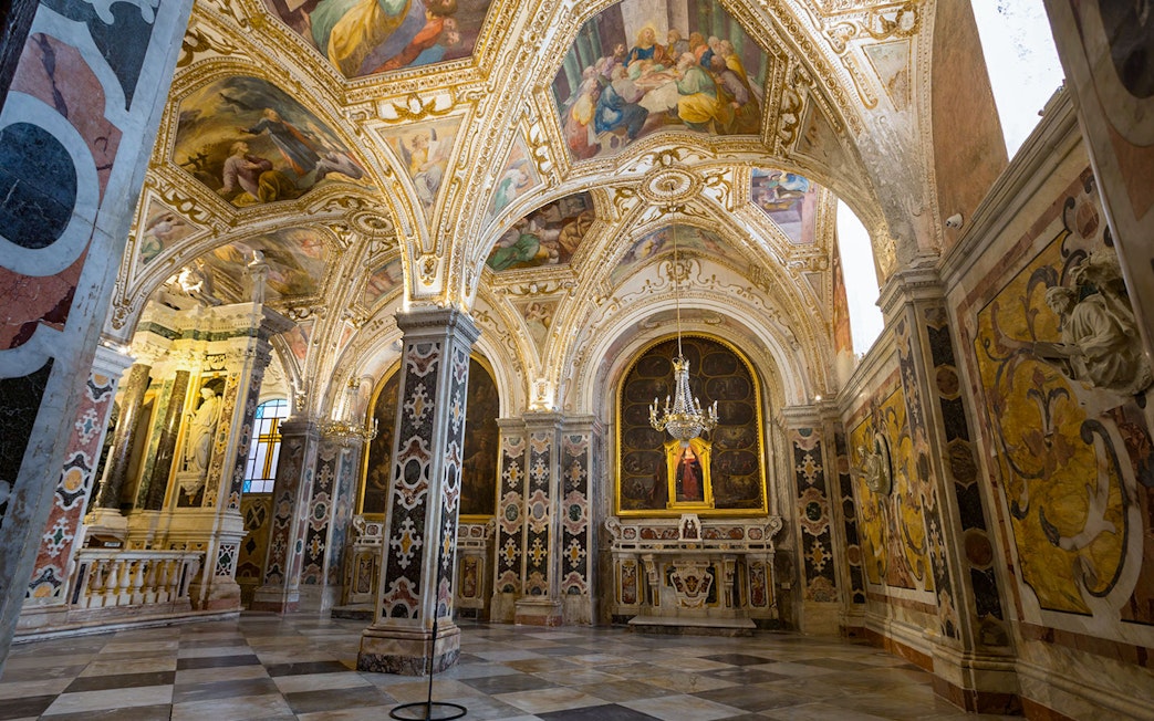 Interior of the ornate crypt in Amalfi Cathedral, featuring detailed frescoes and marble columns.