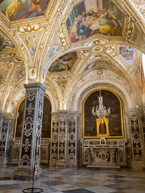 Interior of the ornate crypt in Amalfi Cathedral, featuring detailed frescoes and marble columns.