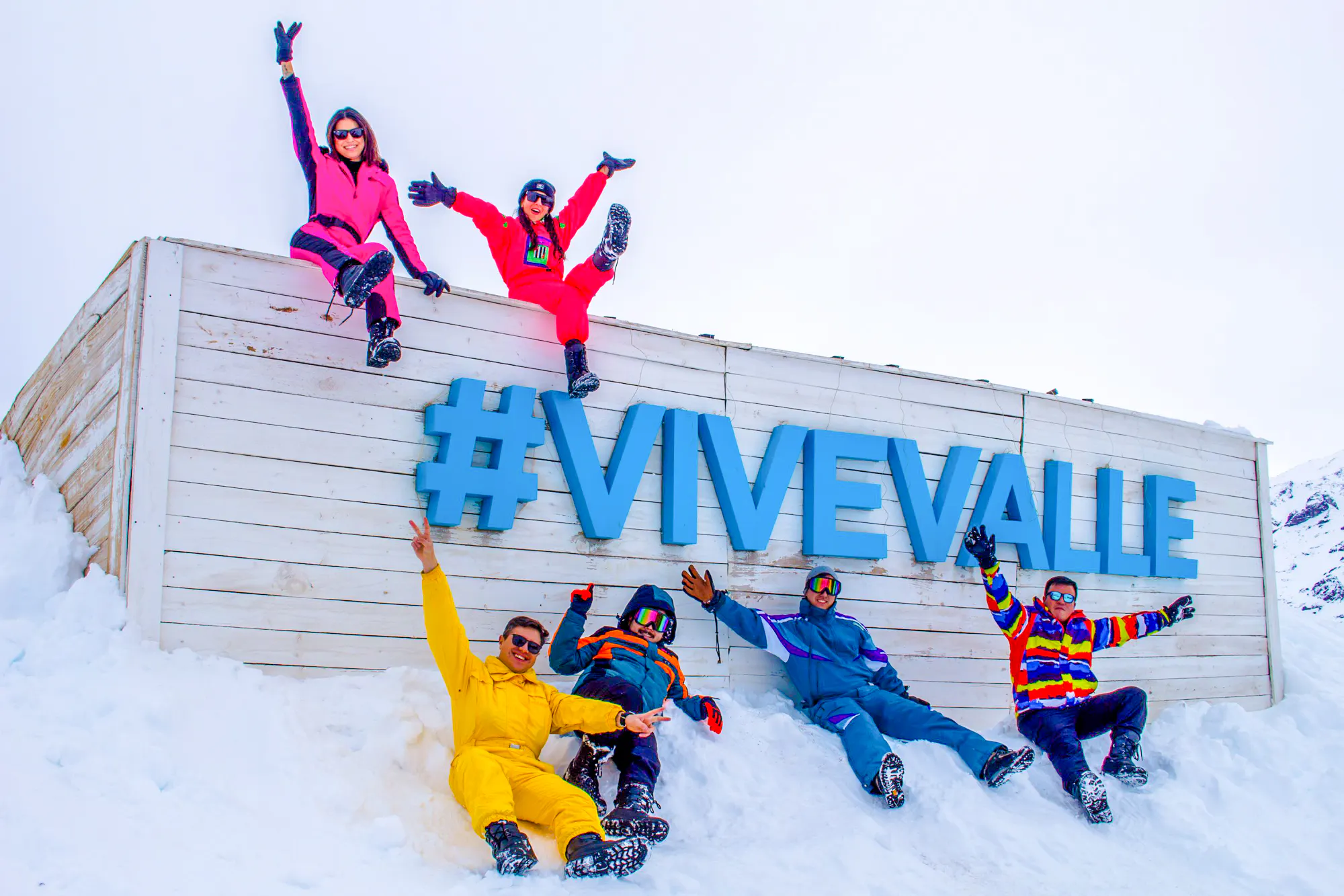 Group enjoying snow at Valle Nevado with #ViveValle sign, Santiago tour.