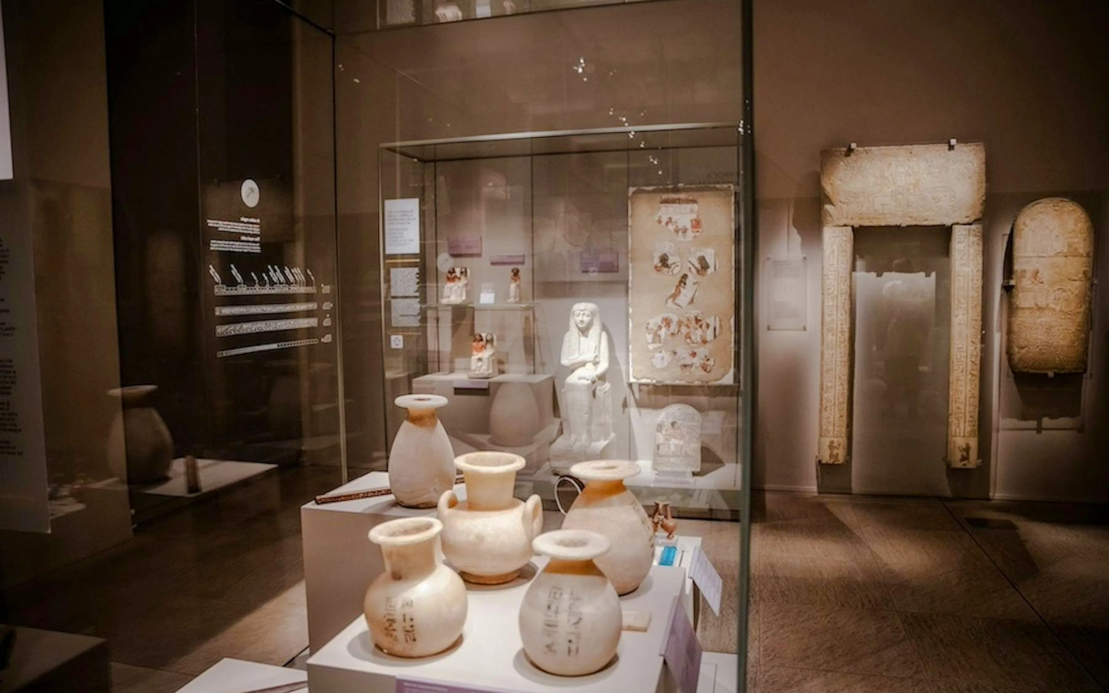 Artifacts and statues displayed in a glass case at the Egyptian Museum in Turin.