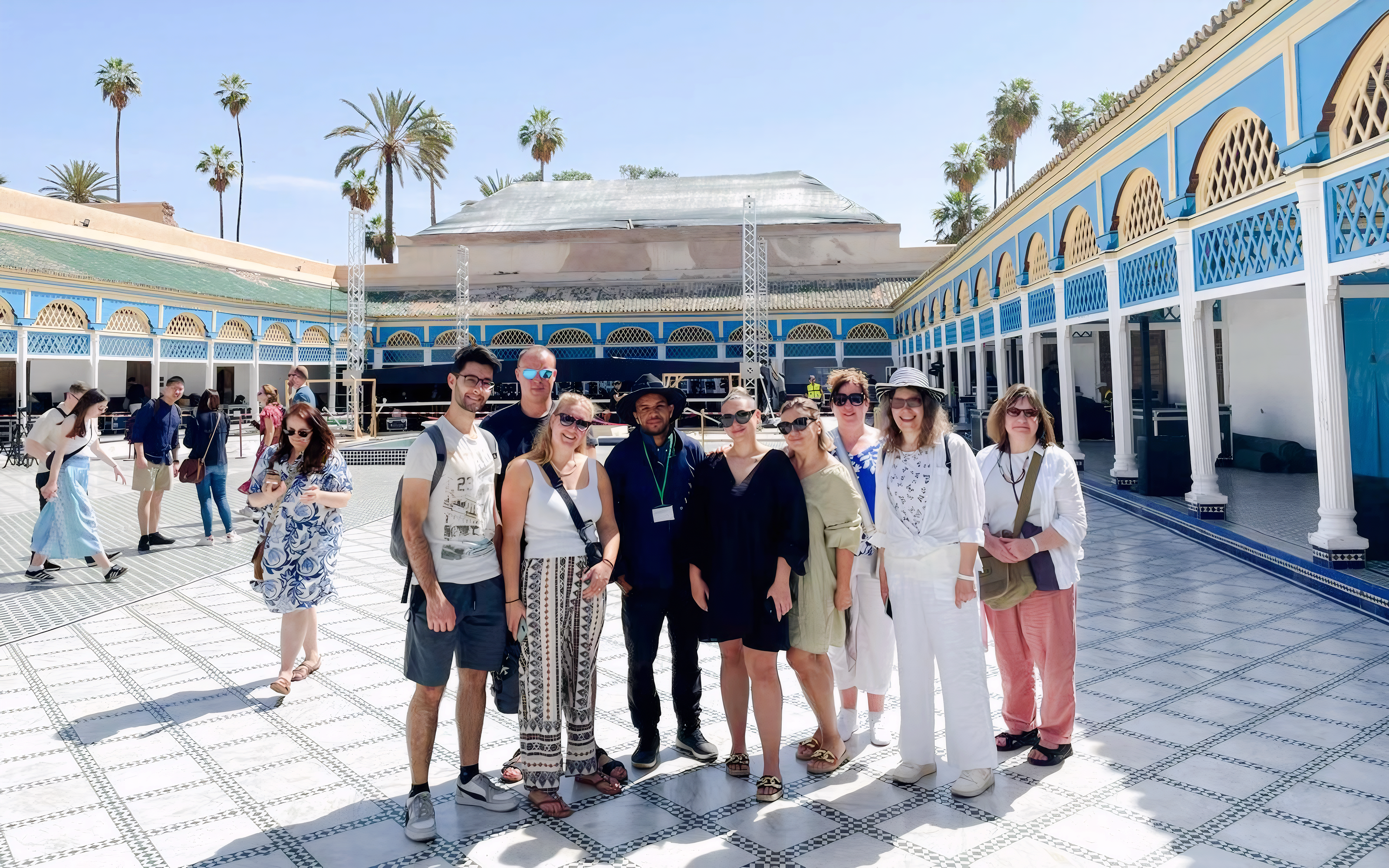 Tour group with guide at Bahia Palace courtyard in Marrakech.