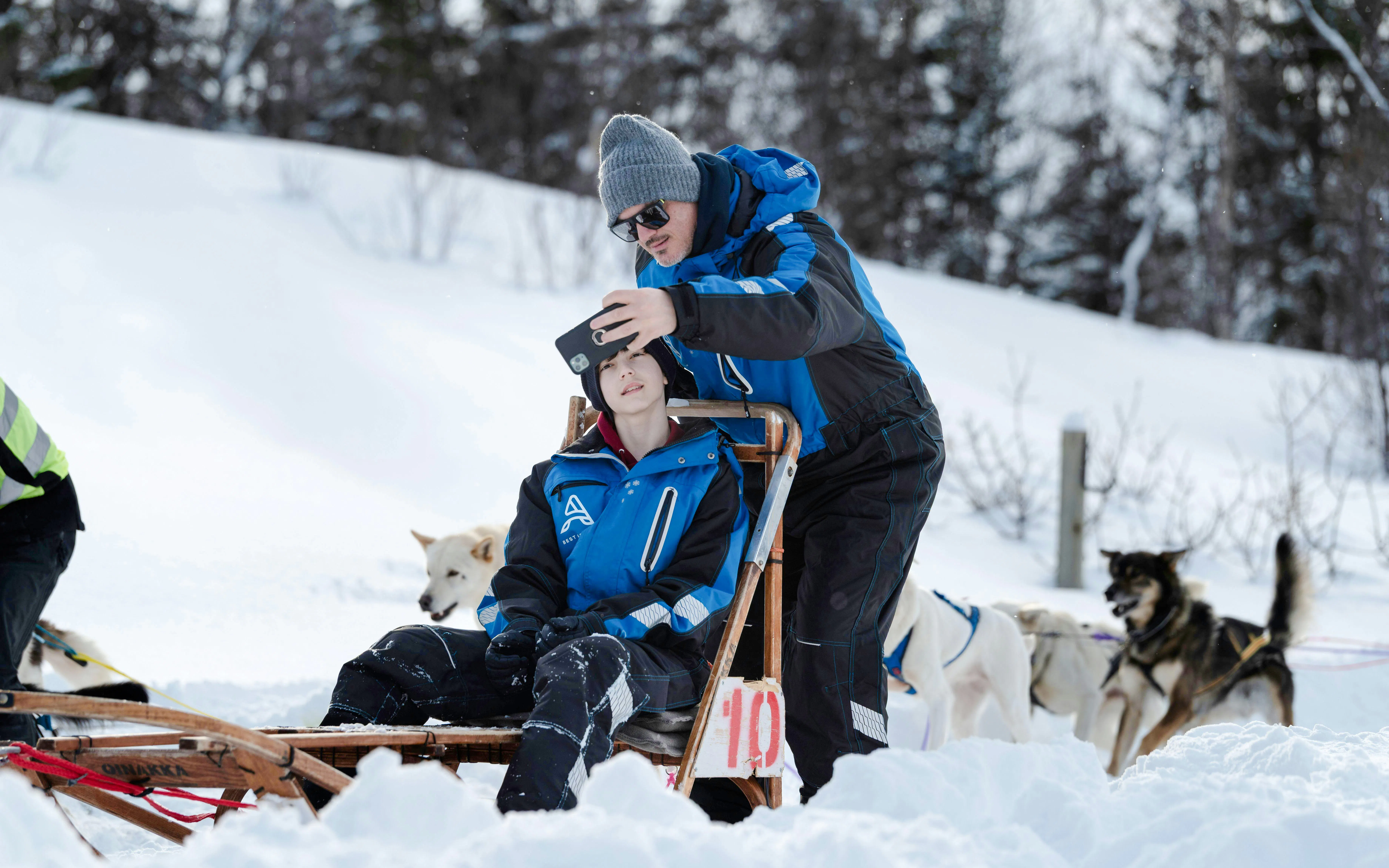 Guests taking a selfie during a dogsledding tour in Tromso.