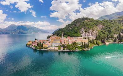 Panoramic view of Lake Como with colorful village and lush hills.