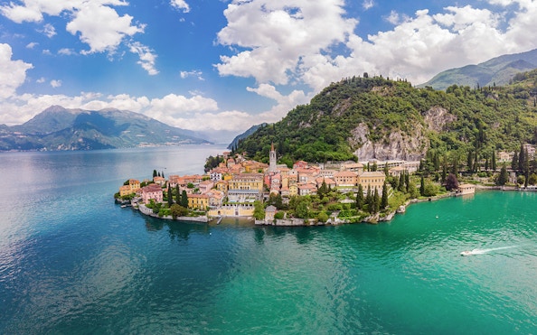 Panoramic view of Lake Como with colorful village and lush hills.