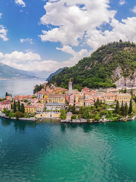 Panoramic view of Lake Como with colorful village and lush hills.