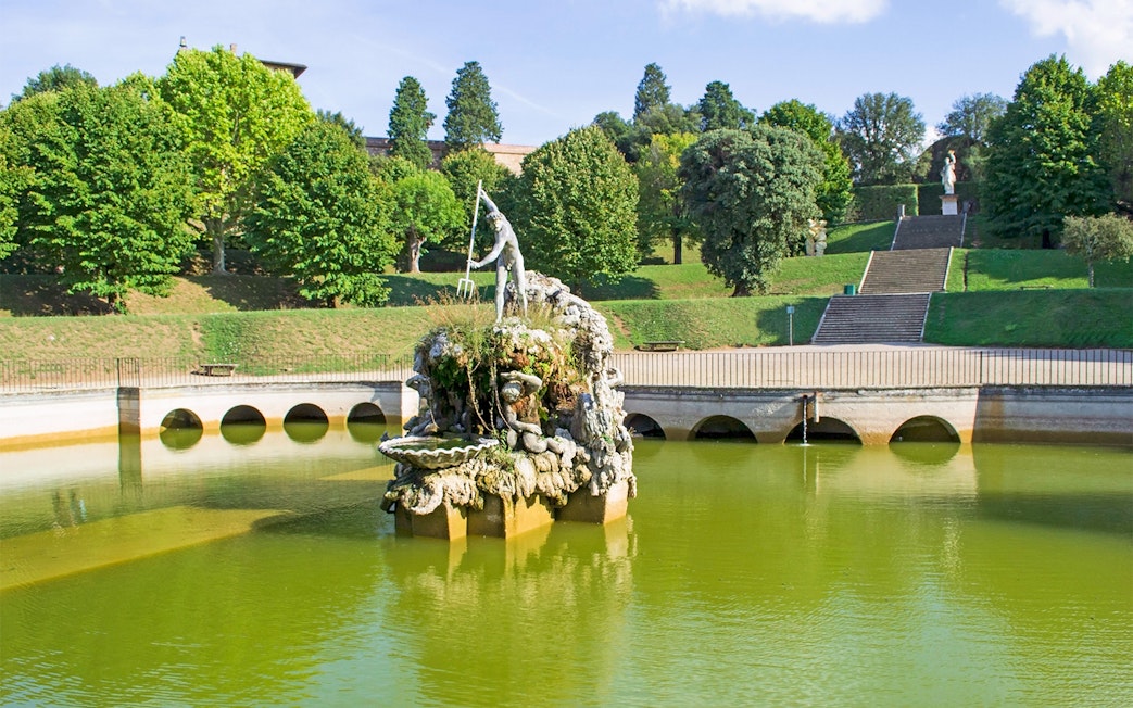 Fountain of Neptune in Boboli Gardens, Florence, surrounded by greenery and water.