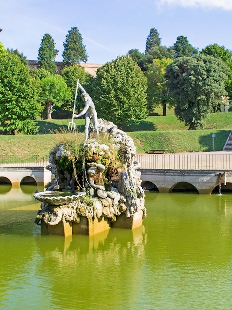 Fountain of Neptune in Boboli Gardens, Florence, surrounded by greenery and water.