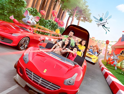 Family enjoying a ride in a red car at Ferrari World Theme Park, surrounded by animated characters.