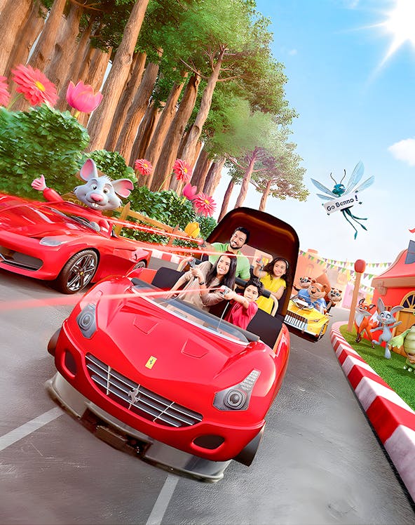 Family enjoying a ride in a red car at Ferrari World Theme Park, surrounded by animated characters.